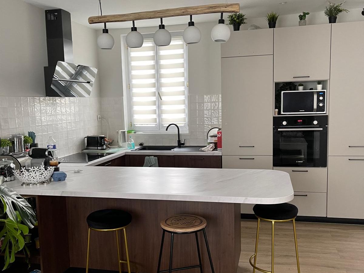Cuisine ouverte avec îlot central et plan de travail bois