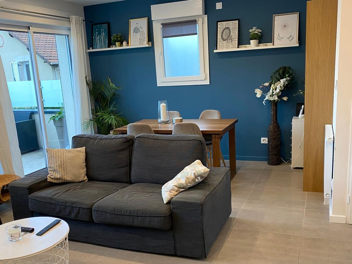 Séjour rénové avec mur bleu et rangements sur mesure